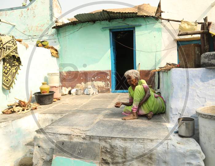 An Elderly Woman Sitting In an Rural Village Poor House