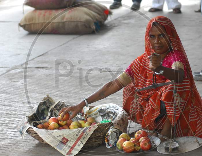 A Woman Vendor Selling Apples