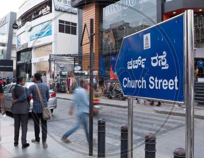 Bengaluru, Karnataka, India - November 08 2019: View of the famous Church street sign board at MG road with the people crossing the street in motion blur
