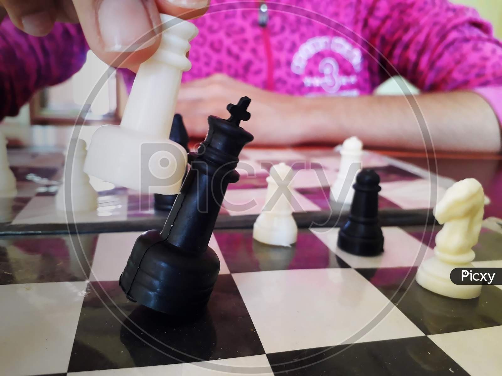 A girl is playing chess and winning the match by beating opponent king