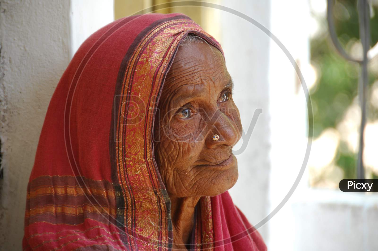 Indian Elderly Woman Standing at a Rural Village House