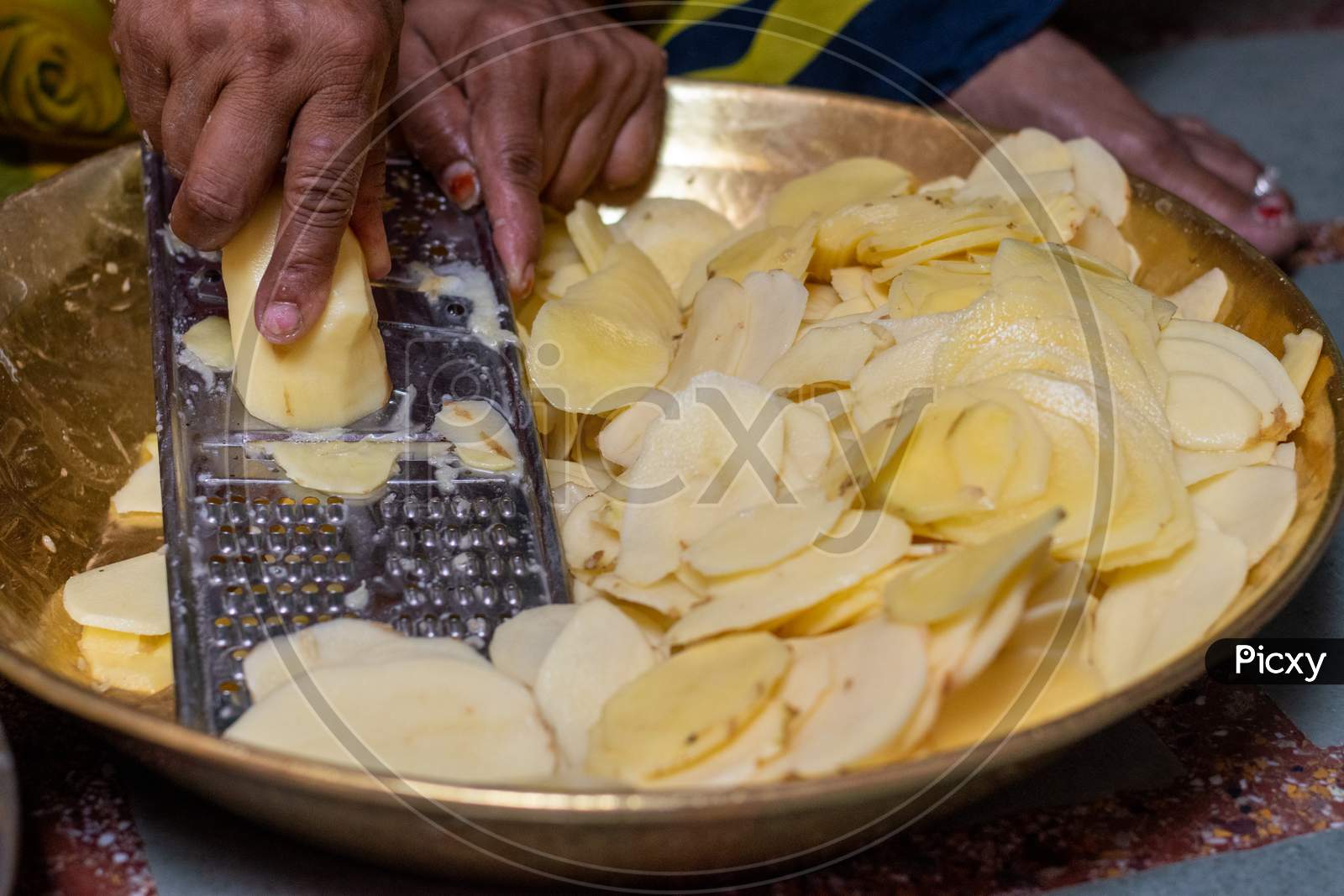 A woman prepares potato chips using chips maker at home