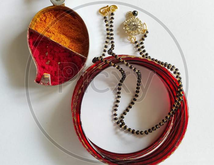 Necklace and bangles on white background. Mangalsutra bangles and kumkum close up view.