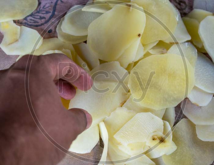 Image of Potato slices are being cut using chips slicer to prepare potato  chips-KM389851-Picxy