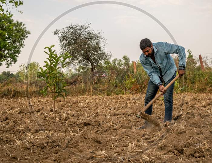 A farmer works at a farm using spade