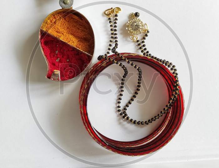 Necklace and bangles on white background. Mangalsutra bangles and kumkum close up view.