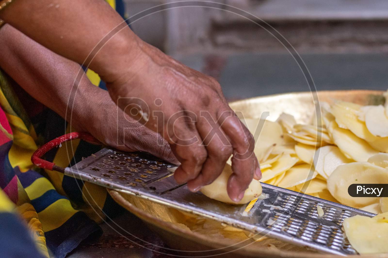 A woman prepares potato chips using chips maker at home