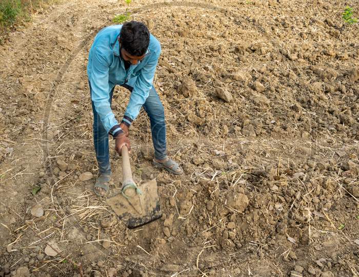 A farmer works at a farm using spade