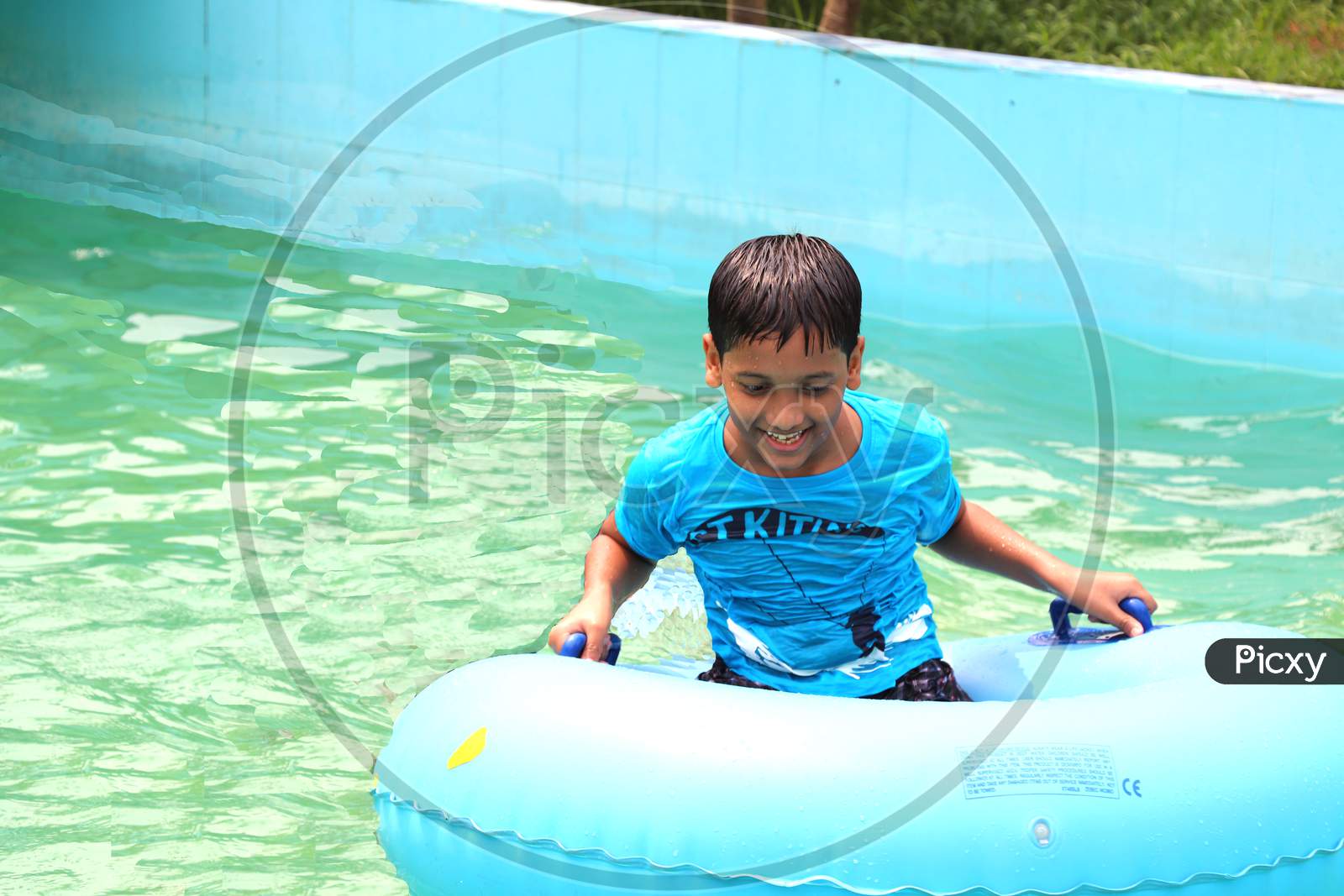 A school boy is enojying at the swimming pool water, very enjoyable moment