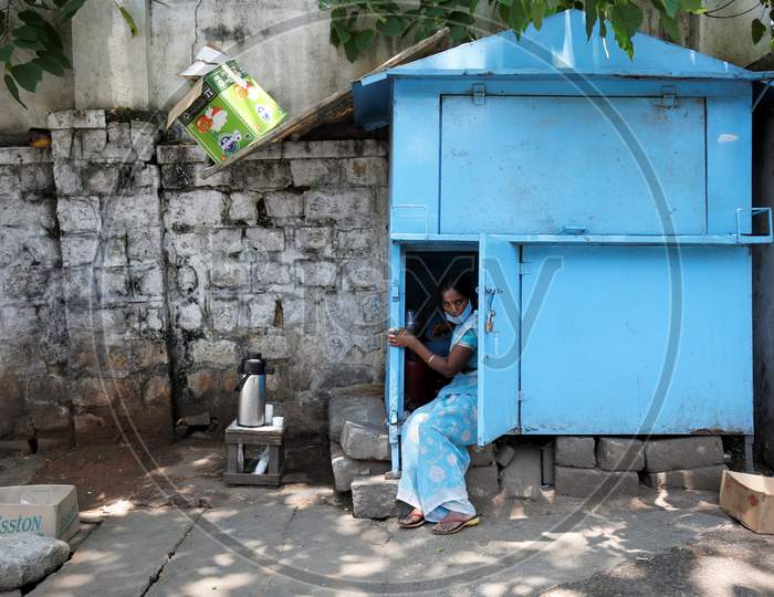 A woman prepares tea inside a partially shuttered kiosk on a pavement during a nationwide lockdown to prevent the spread of coronavirus (COVID-19) in Bangalore, India, April 30, 2020.