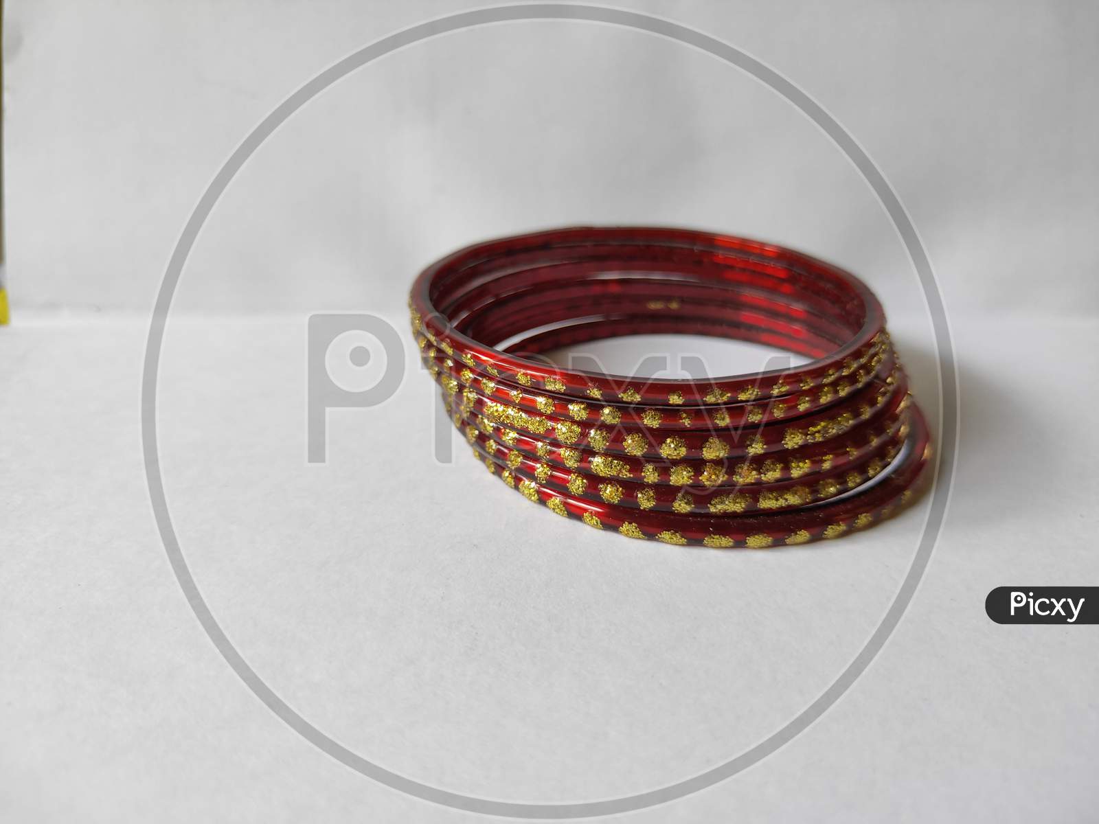 Bangles on white background. Red bangles on plain background. Glass jewelry bangles close up view.