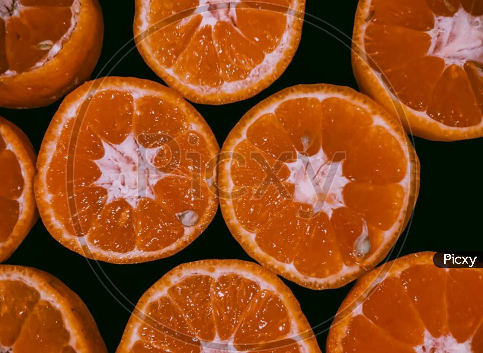 Orange slices kept along each other having seeds in them