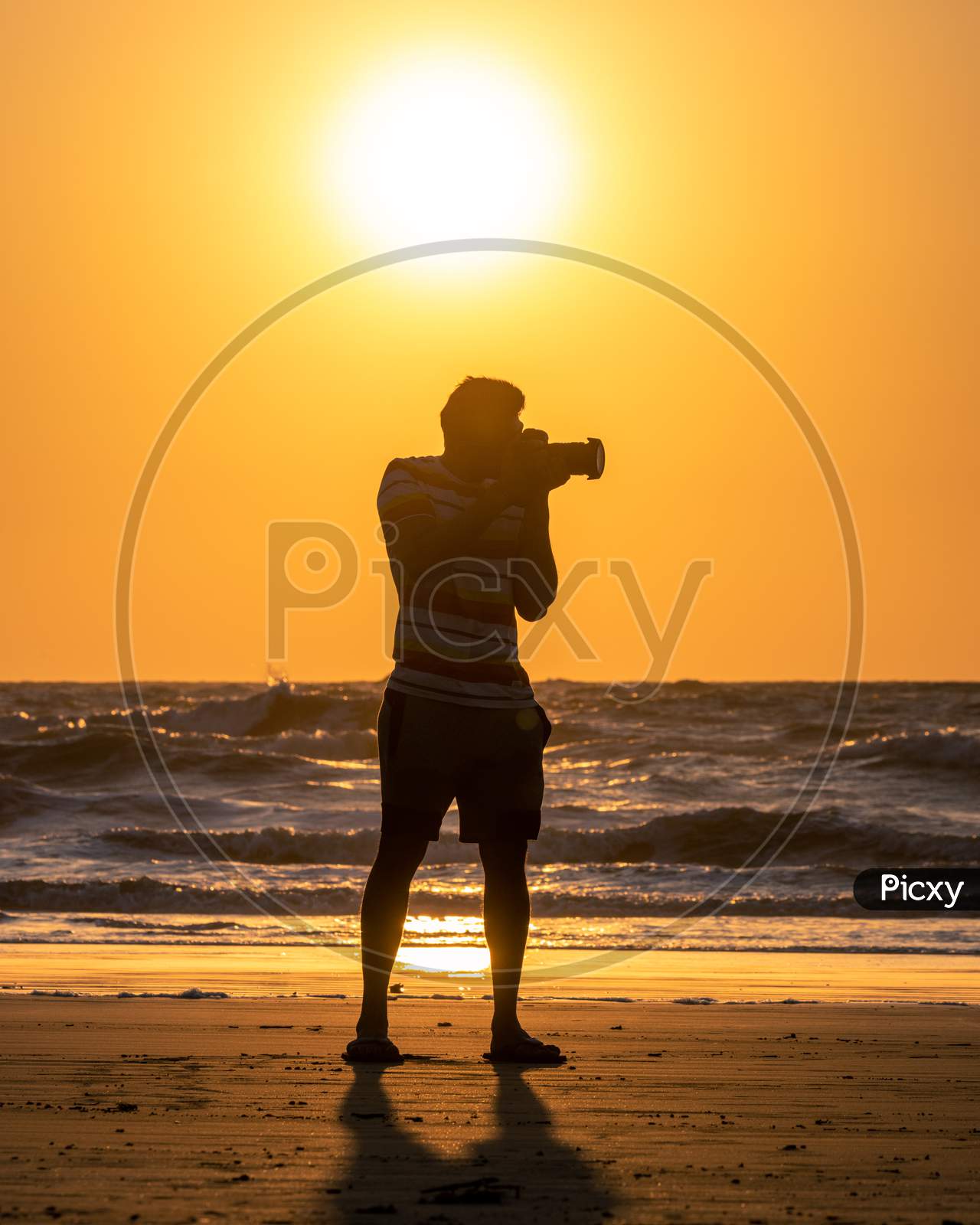 Silhouette Of a Photographer At a Beach Over a Sunset Sky