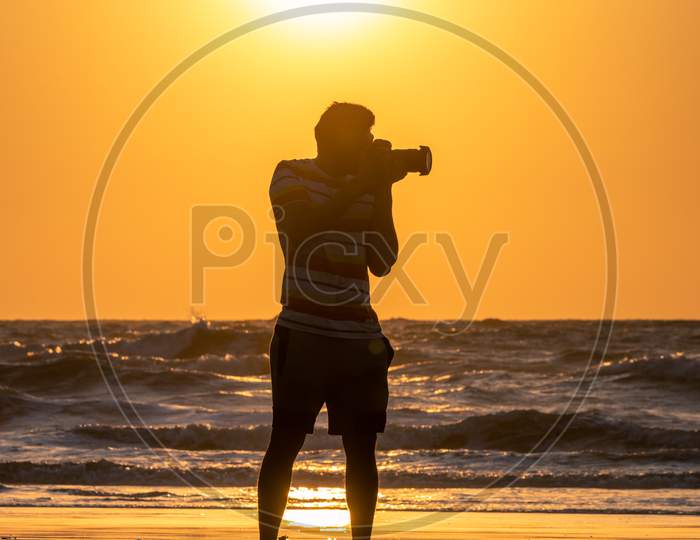 Silhouette Of a Photographer At a Beach Over a Sunset Sky