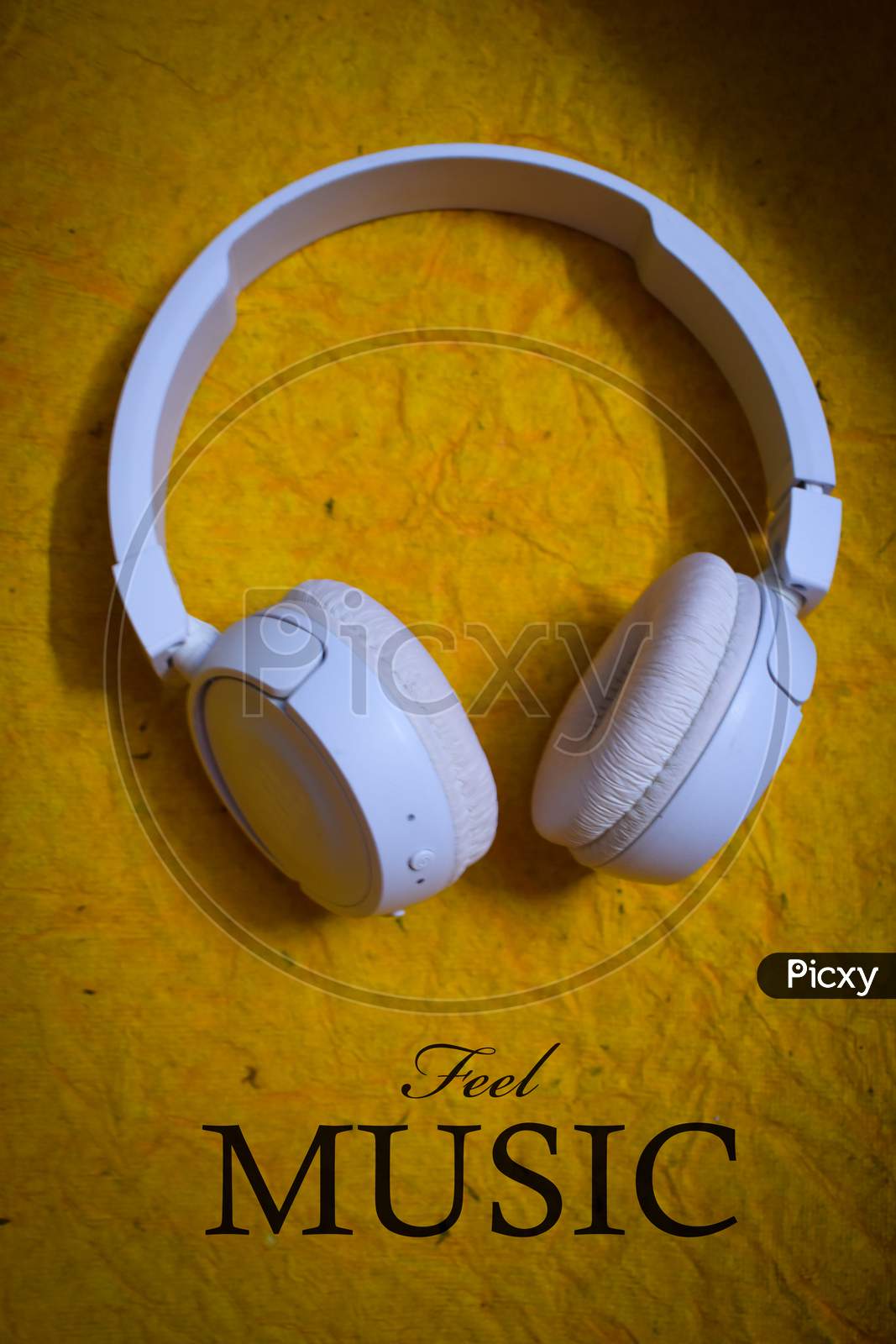 white Bluetooth headphone on a yellow background
