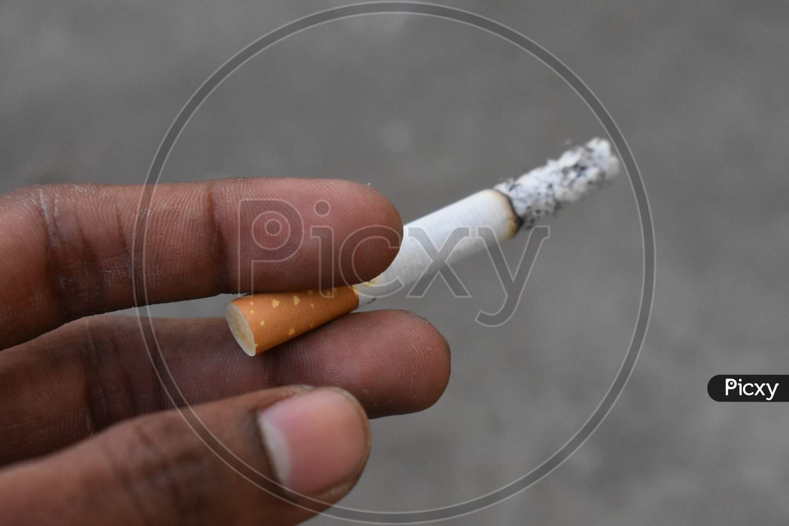 white and yellow cigarette in a man hand