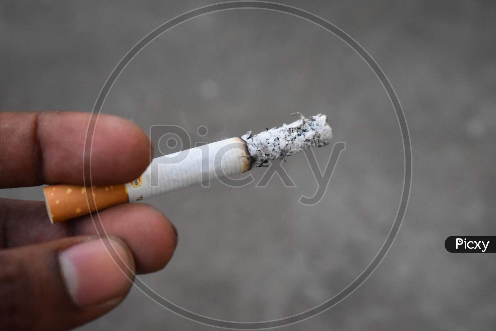 white and yellow cigarette in a man hand
