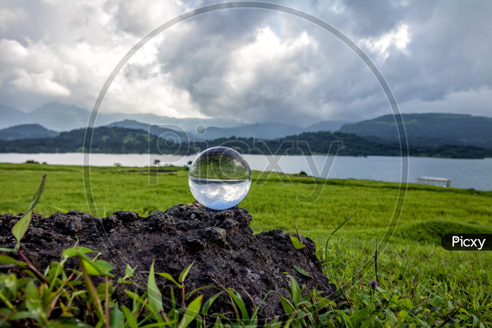 Lens ball Kept On Rock With Lake And Hills In Background Shot At BHANDARDARA