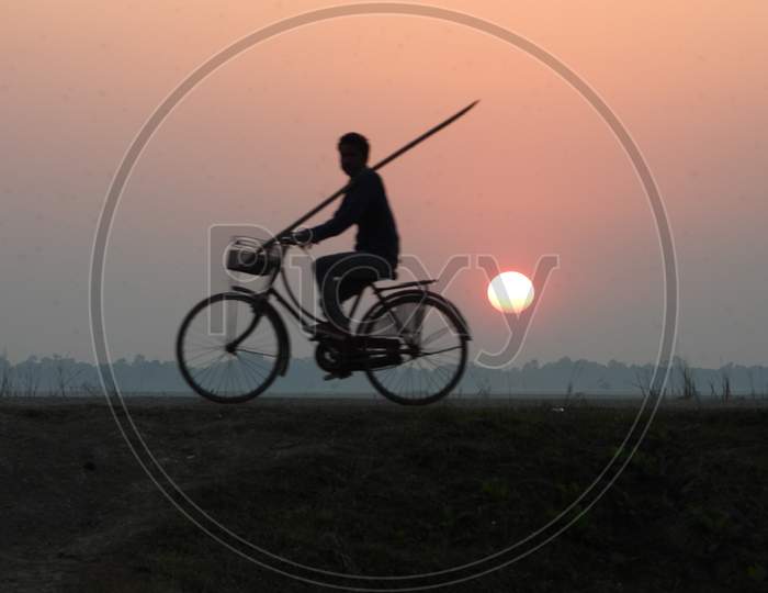 Silhouette of man Riding Bicycle Over a Sunset Sky