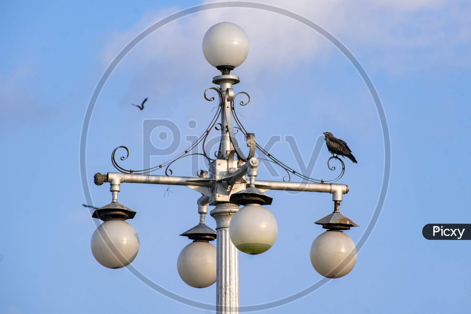 The isolated vintage lamp on an iron column against the blue sky