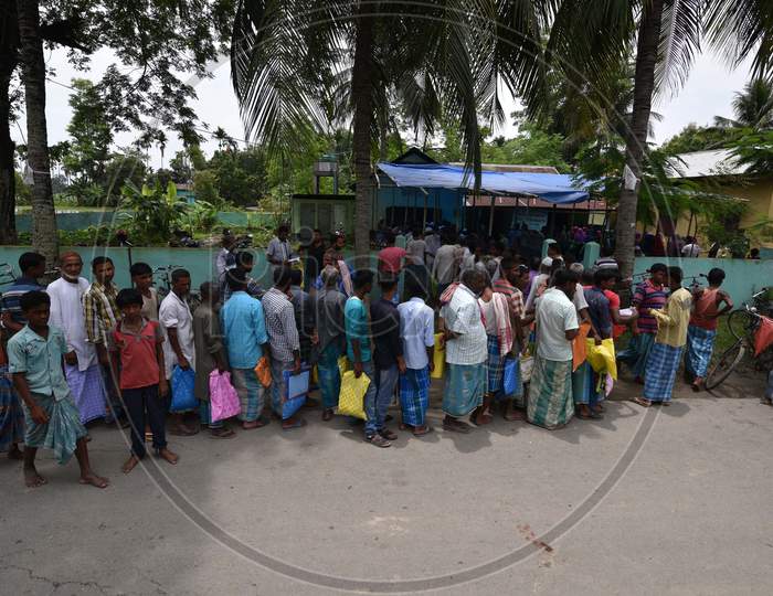 People stand in a queue to check their names on the draft list of the National Register of Citizens (NRC) outside an NRC centre in Assam