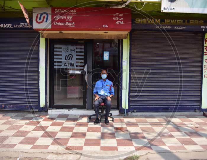 A Security Guard Wear Mask As He Sit Outside A Bank  Atm  During A Nationwide Lockdown In The Wake Of Coronavirus Pandemic, In Nagaon District Of Assam ,India