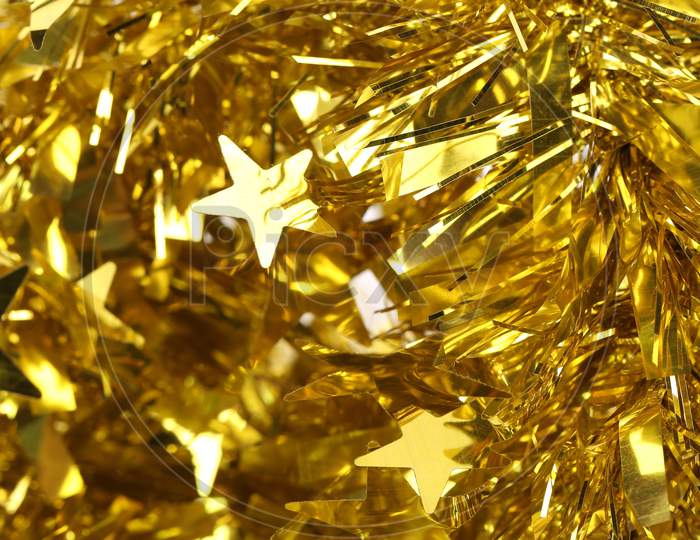 Christmas Golden Tinsel With Stars. Whole Background.