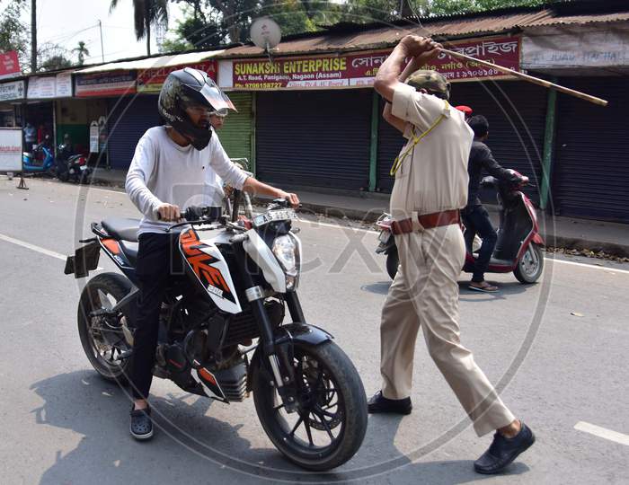 A Police Officer Wields His Baton Against A Man As A Punishment For Breaking The Lockdown Rules After India Ordered A 21-Day Nationwide Lockdown To Limit The Spreading Of Coronavirus Disease (Covid-19)  In Nagaon District Of Assam On Mar 26,2020.