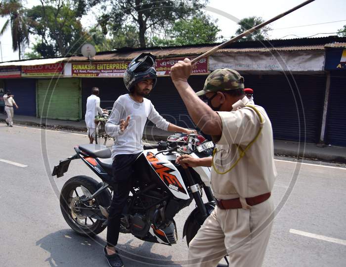 A Police Officer Wields His Baton Against A Man As A Punishment For Breaking The Lockdown Rules After India Ordered A 21-Day Nationwide Lockdown To Limit The Spreading Of Coronavirus Disease (Covid-19)  In Nagaon District Of Assam On Mar 26,2020
