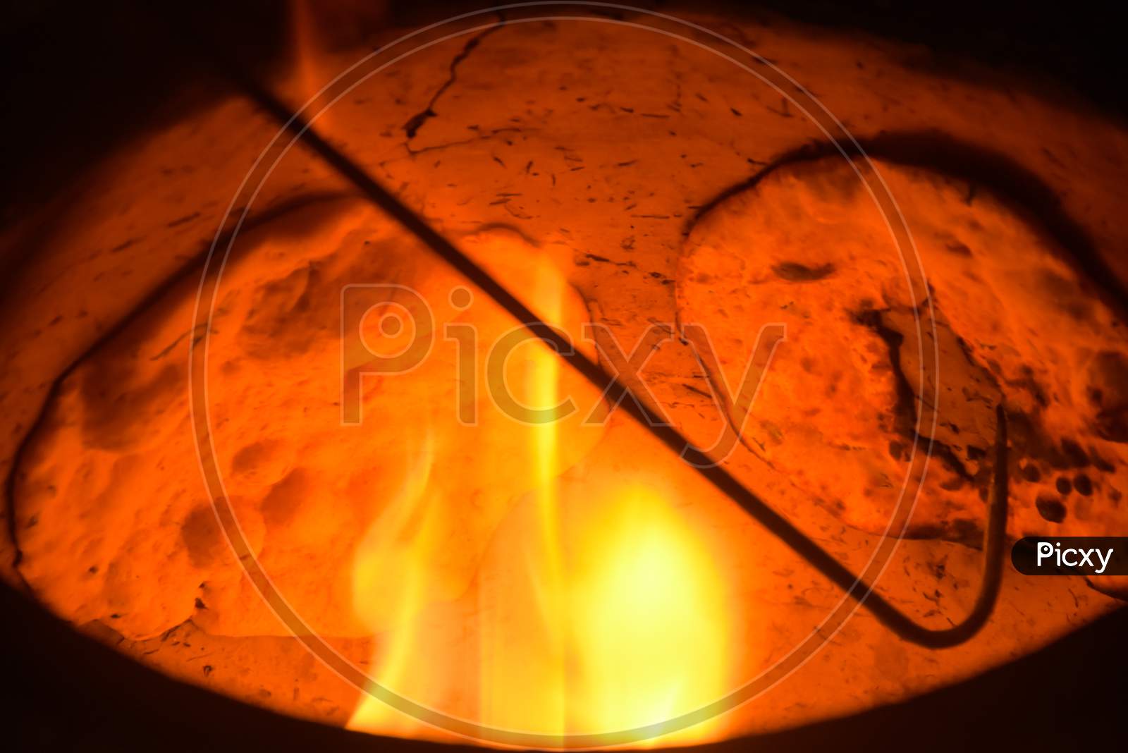 man coking bread on fire