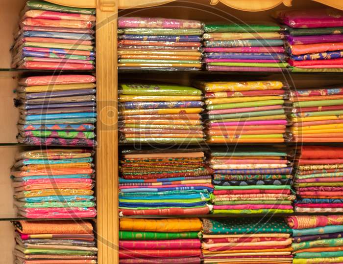 Traditional colorful Indian clothes stacked in a textile showroom