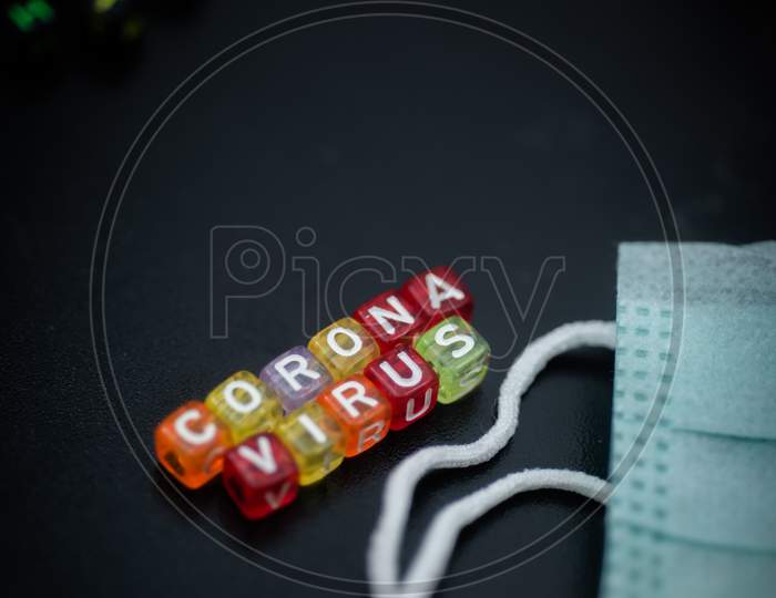 Colorful Word Corona Virus English Alphabet Cube On Black Color Background And Face Mask , Selective Focus