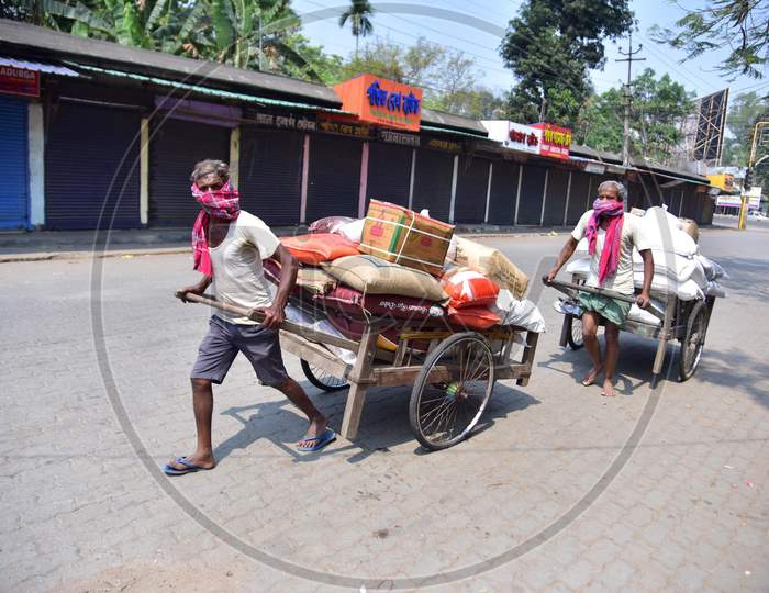 Workers  Push A Cart With  Groceries During A Nationwide Lockdown In The Wake Of Coronavirus Pandemic, In Nagaon District Of Assam ,India