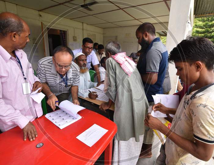 People stand in a queue to check their names on the draft list of the National Register of Citizens (NRC) outside an NRC centre in Assam