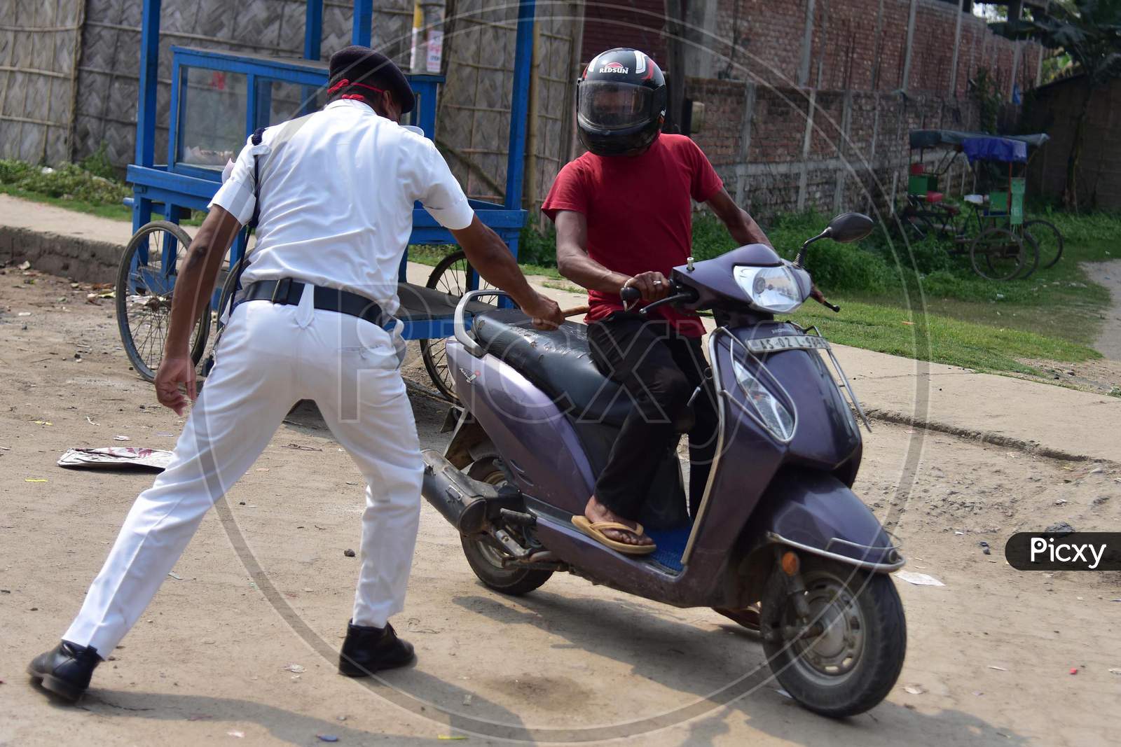 A Police  Officer Wields His Baton Against A Man As A Punishment For Breaking The Lockdown Rules After India Ordered A 21-Day Nationwide Lockdown To Limit The Spreading Of Coronavirus Disease (Covid-19) In Nagaon District Of Assam,India