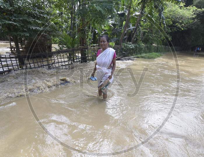 Flood affected villagers move to a safer place at a village near Kampur in Nagaon districts of Assam