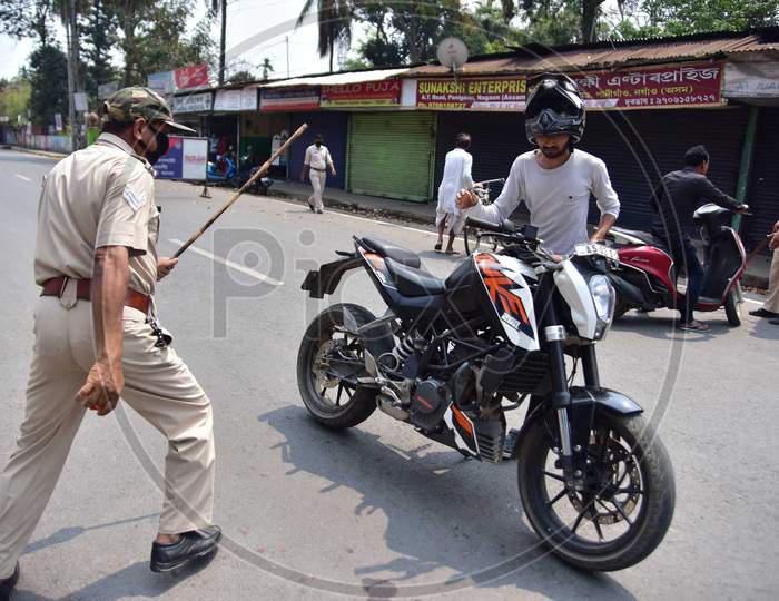 A Police Officer Wields His Baton Against A Man As A Punishment For Breaking The Lockdown Rules After India Ordered A 21-Day Nationwide Lockdown To Limit The Spreading Of Coronavirus Disease (Covid-19)  In Nagaon District Of Assam On Mar 26,2020.