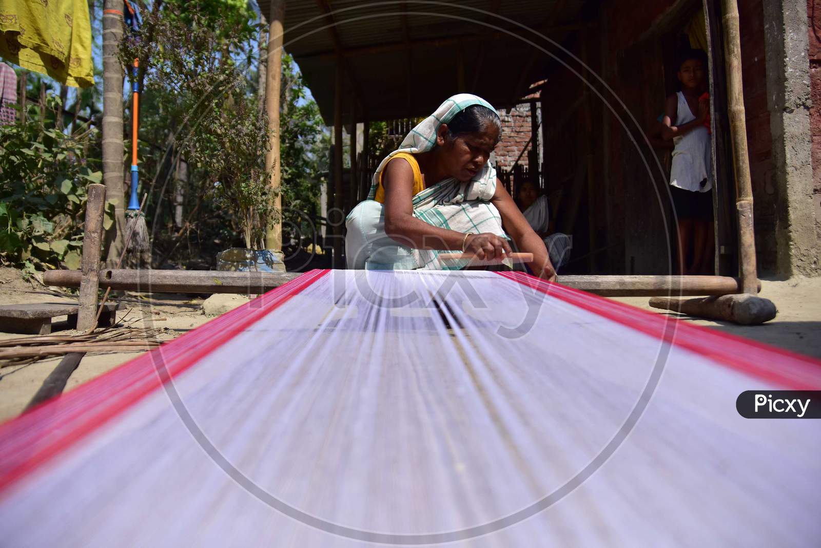 Women Busy In Weaving Traditional Assamese Gamosa Ahead Of Rongali Bihu Festival  During The Nationwide Lockdown Imposed In Wake Of Coronavirus Pandemic, In Nagaon District Of Assam On April 02,2020.