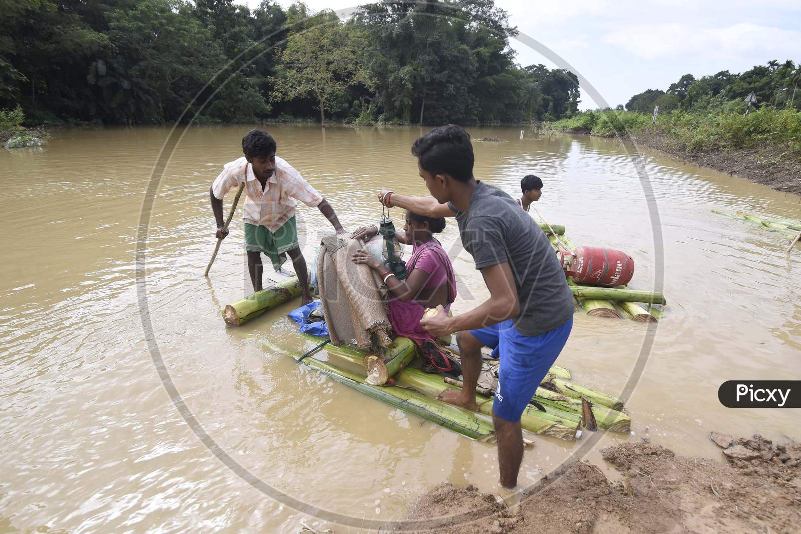 Flood affected villagers move to a safer place at a village near Kampur in Nagaon districts of Assam
