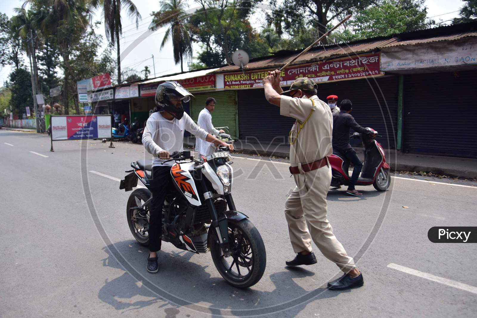 A Police Officer Wields His Baton Against A Man As A Punishment For Breaking The Lockdown Rules After India Ordered A 21-Day Nationwide Lockdown To Limit The Spreading Of Coronavirus Disease (Covid-19)  In Nagaon District Of Assam On Mar 26,2020