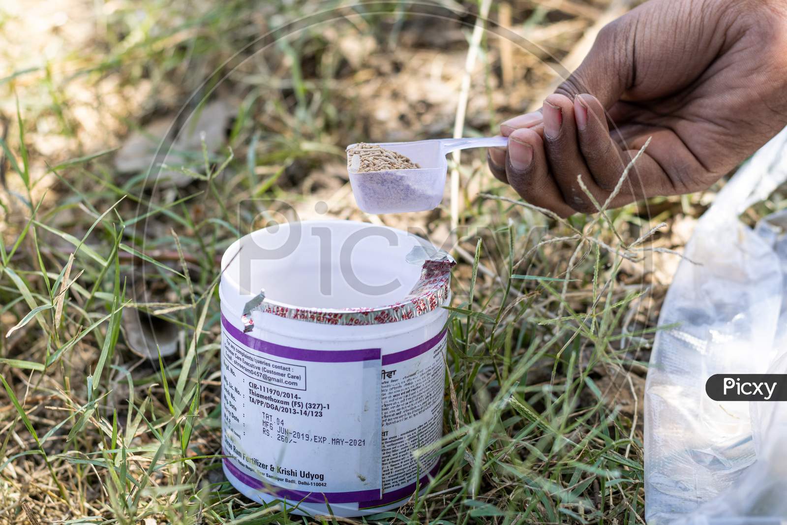 A farmer taking Thaimethoxam insecticide into a spoon