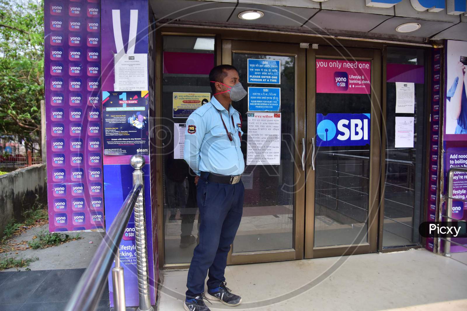 A Security Guard Wear Mask As He  Stand Outside A Bank Atm During A Nationwide Lockdown In The Wake Of Coronavirus Pandemic, In Nagaon District Of Assam On Mar 26,2020.