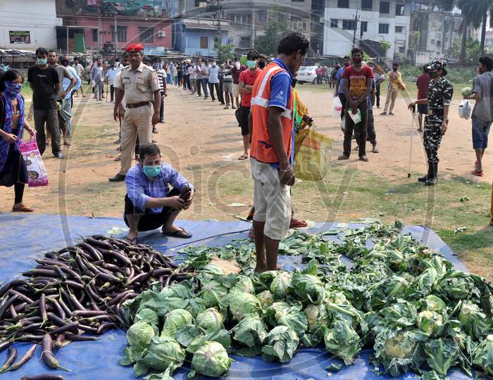 People Maintain Safe Distance  As They Stand In A Queue To Buy Vegetables, Supplied By The State Food Supply Department, During Third  Day Of Complete Lockdown In The Wake Of The Corona Virus Pandemic In Guwahati ,India