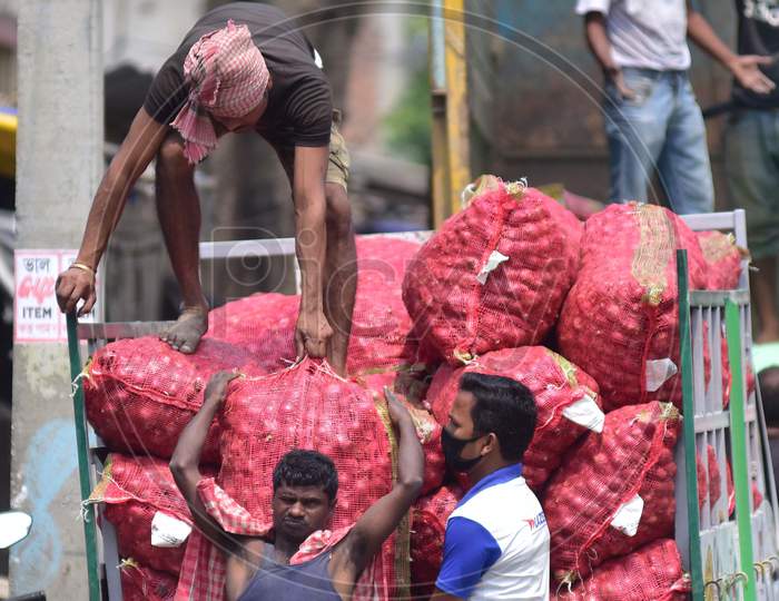 Workers Unload Vegetables From A Truck At A Wholesale Market During The Nationwide Lockdown Imposed In The Wake Of Coronavirus Pandemic, In Nagaon District Of Assam On March 27,2020
