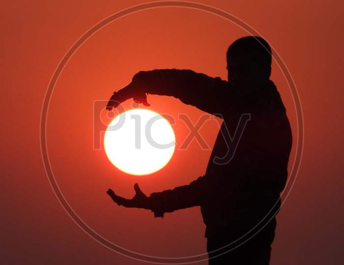 Silhouette Of a  Man Holding Like Sunset Sun