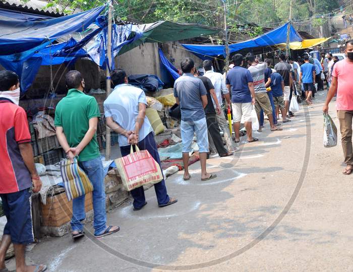 People Maintain Safe Distance  As They Stand In A Queue To Buy Vegetables, Supplied By The State Food Supply Department, During Third  Day Of Complete Lockdown In The Wake Of The Corona Virus Pandemic In Guwahati ,India