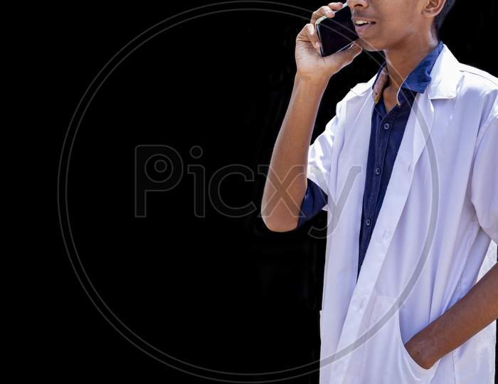 Cropped Shot Of Male Doctor Speaking On The Smart Phone, Standing Isolated Over Black Backgrounds