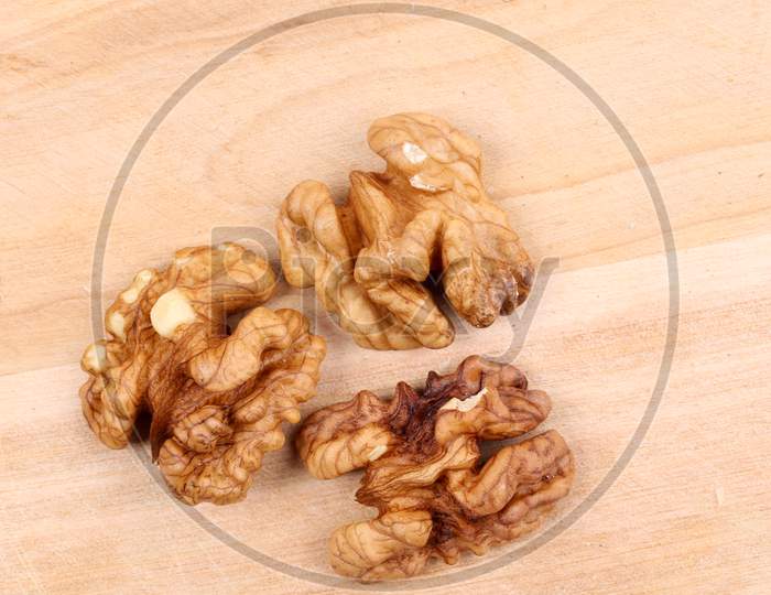 Close Up Of Three Walnut Kendels. Isolated On A Wooden Background.