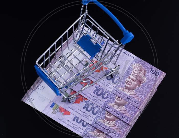 Banknotes Malaysia Currency Inside A Shopping Cart On A Black Background.