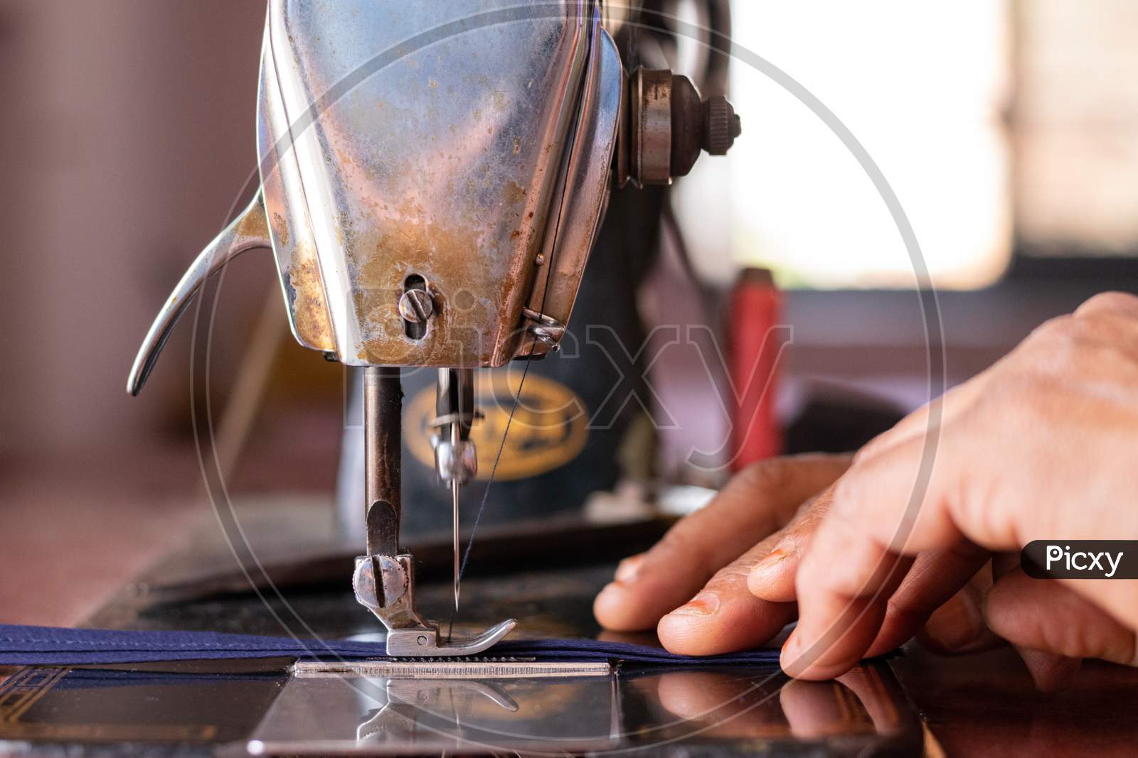 A woman working on a sewing machine at home closeup